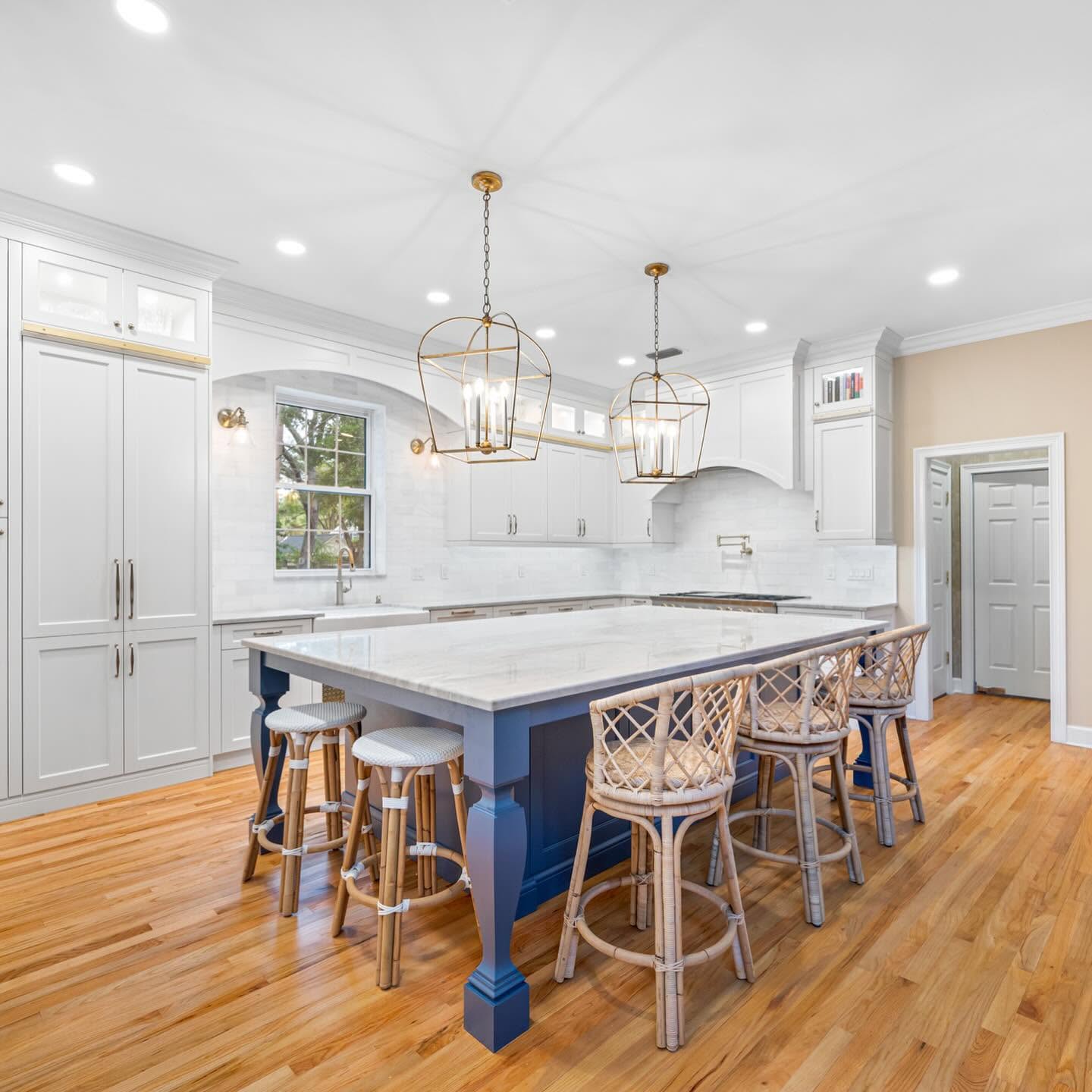 Custom kitchen with navy island and gold pendants